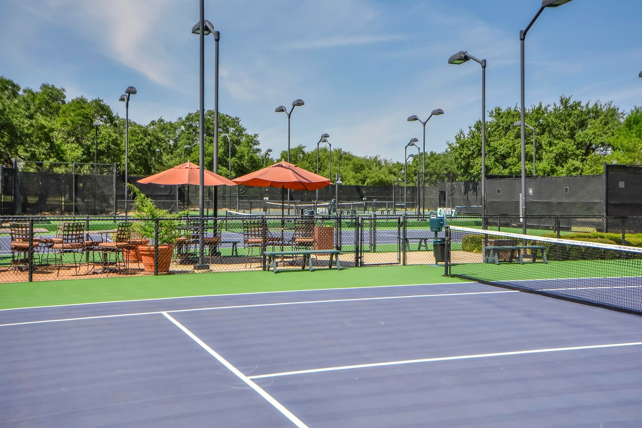 Cimarron Hills tennis courts with orange umbrellas and seating